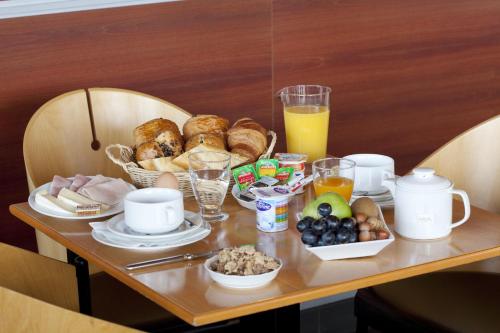 a table topped with plates of food and drinks at Hotel Lille Europe in Lille