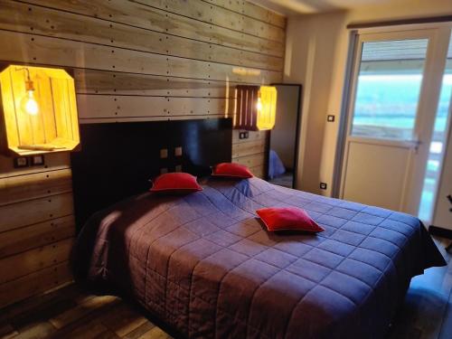 a bedroom with a large bed with red pillows at Auberge De La Durdent in Héricourt-en-Caux