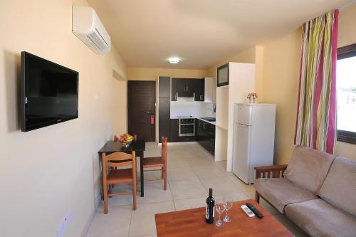 a living room with a couch and a table at Nelia Gardens in Ayia Napa