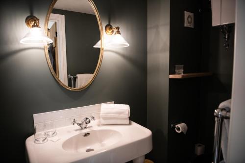 a bathroom with a sink and a mirror at The Cotley Inn in Wambrook