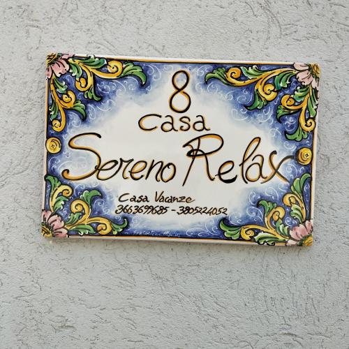 a sign on a wall that reads casa serrano relax at Sereno relax in Scicli