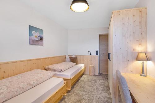 a room with two beds and a lamp in it at Living Lerchna - Apartment Abendrot in Maranza