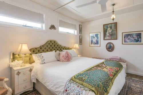 um quarto com uma grande cama branca num quarto em 'Ooh La La' is a quirky French inspired apartment em Goolwa South