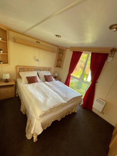 科爾撤沃的住宿－MIĘDZY NAMI domki nad jeziorem，一间卧室设有一张大床和一个窗户。