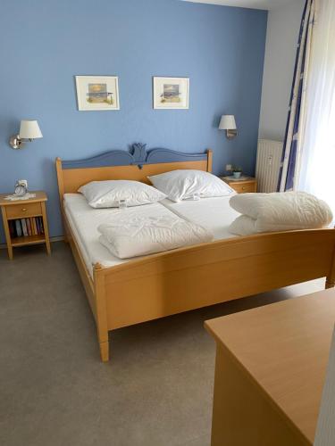 グロヴェにあるSchönes Appartment mit Fernblickの青い壁のベッドルームのベッド1台