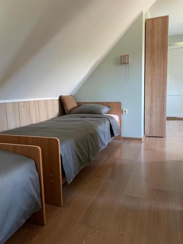 1 dormitorio con 2 camas y escalera en Jasmīni, en Ventspils