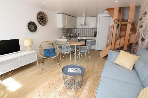 un salon avec un canapé bleu et une cuisine dans l'établissement La Marinière entre Port et Plage, à Dieppe