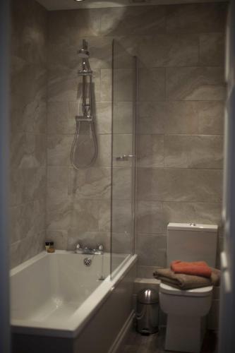 a bathroom with a tub and a toilet and a shower at Trelough House B&B in Wormbridge