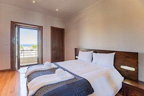 a bedroom with a large bed with two towels on it at Mindelo Villa Beach by LovelyStay in Mindelo