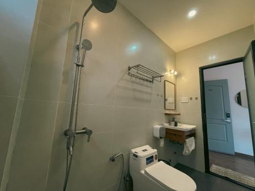 a bathroom with a shower and a toilet and a mirror at Villa Délight House “Stay&Chill” in Da Lat