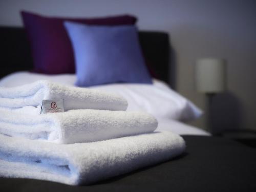 a pile of towels sitting on top of a bed at Auberge de Bellelay Restaurant Chez Aron Balde in Bellelay