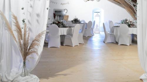 a white room with white tables and white chairs at Auberge de Bellelay Restaurant Chez Aron Balde in Bellelay