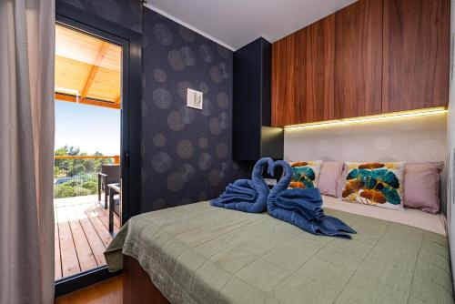 Un dormitorio con una cama con toallas azules. en Island of Heron - La Vie est Belle en Drage