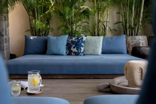 a blue couch in a living room with plants at Clay Beach Samui - Beachfront Villas in Amphoe Koh Samui