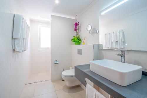 a white bathroom with a sink and a toilet at Apartamentos Vista Sur in Playa de las Americas