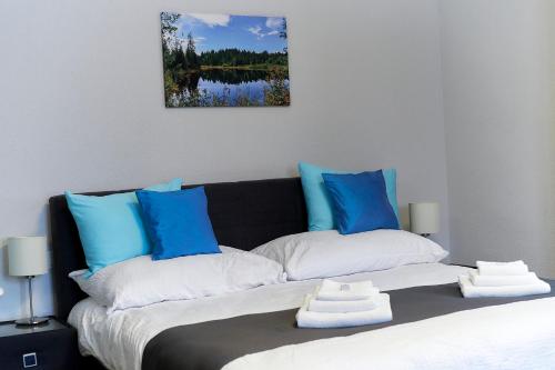 a bedroom with a bed with blue and white pillows at Auberge de Bellelay Restaurant Chez Aron Balde in Bellelay