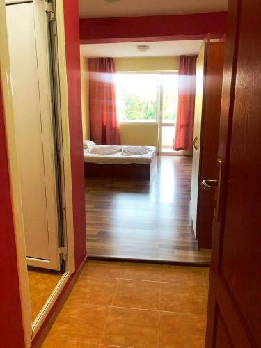 a hallway with a room with a bed and a window at Arkadia Guest House in Primorsko