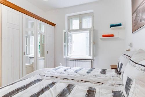a white bedroom with a bed and a window at Luxury & Quiet charming 2bds near river - Nek2nd in Prague