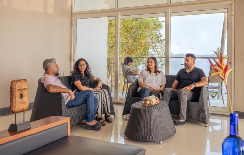 a group of people sitting in chairs in a room at Waters Edge Kochi - a VKation Experience in Cochin