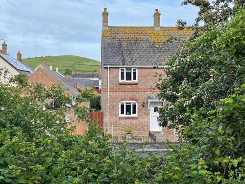 a red brick house with a white door at The Beach House in Bridport