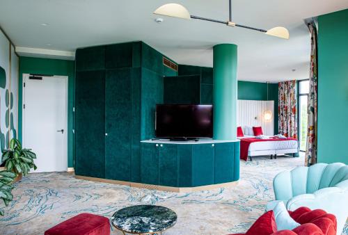 sala de estar con paredes verdes y TV de pantalla plana en Ego SPA - Adults Only, en Birštonas