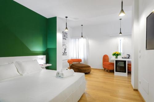 a bedroom with a white bed and a green wall at Quintocanto Hotel & Spa in Palermo