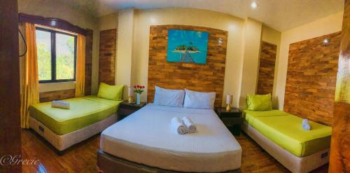 a bedroom with two beds with lime green cushions at Mabini Hotel in Mambajao