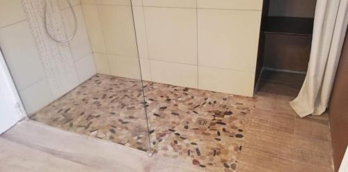 a shower with rocks on the floor in a bathroom at Maison familiale Jardin parking, 10 min plage, 1* in Saint-Cyr-sur-Mer