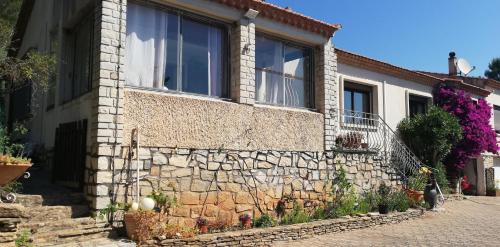 a house with a stone wall and a window at Maison familiale Jardin parking, 10 min plage, 1* in Saint-Cyr-sur-Mer