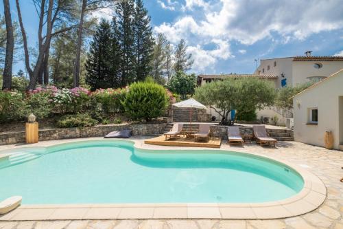 une piscine dans une cour avec des chaises et une maison dans l'établissement REVES DE PAMPA L Atelier, à Lorgues