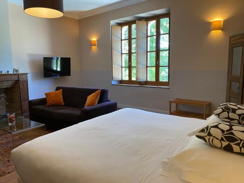 a bedroom with a large bed and a couch at Logis Hôtel Château De Palaja in Carcassonne