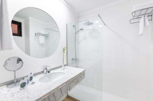 a white bathroom with a sink and a mirror at MUR Neptuno Gran Canaria - Adults Only in Playa del Ingles