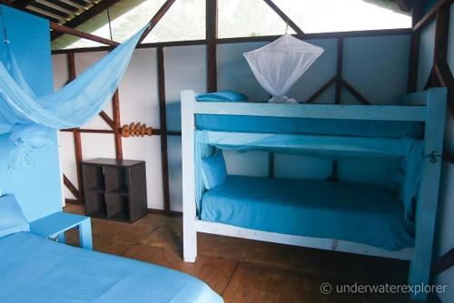 a bedroom with a blue bed with an umbrella at Underwater Explorer in Ponta do Ouro