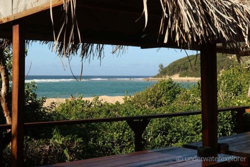 a view of the beach from a straw umbrella at Underwater Explorer in Ponta do Ouro