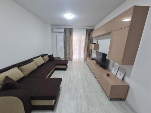 ein Wohnzimmer mit einem Sofa und einem TV in der Unterkunft Apartament Moghioros Park Residence DUM1 in Bukarest