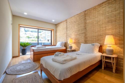 sypialnia z 2 łóżkami i ceglaną ścianą w obiekcie Bamboo AP by PortugalActive Sea n' Mountain View w mieście Viana do Castelo