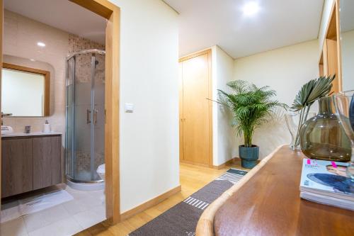 W łazience znajduje się umywalka, prysznic i drewniany stół. w obiekcie Bamboo AP by PortugalActive Sea n' Mountain View w mieście Viana do Castelo