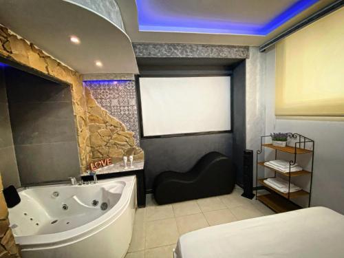 a bathroom with a tub and a sink and a bath tub at Aparta suite la nuit in Calafell