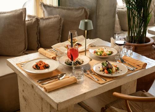 a table with plates of food and glasses of wine at Garden Downtown Prishtina in Pristina