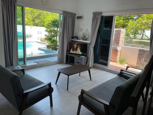 a living room with a tv and a table at My Beach Villa in Port Dickson
