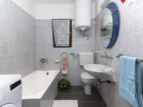 łazienka z umywalką, toaletą i lustrem w obiekcie Apartments Ana 418 w Fažanie