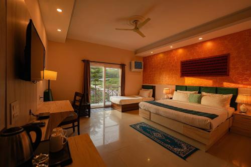 a bedroom with a bed and a desk and a window at Hotel 360 by D'Polo Dharamshala in Dharmsala