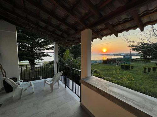 a balcony with two chairs and a view of the ocean at My Beach Villa in Port Dickson