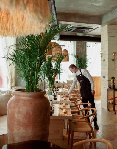 a man standing at a table in a restaurant at Garden Downtown Prishtina in Pristina