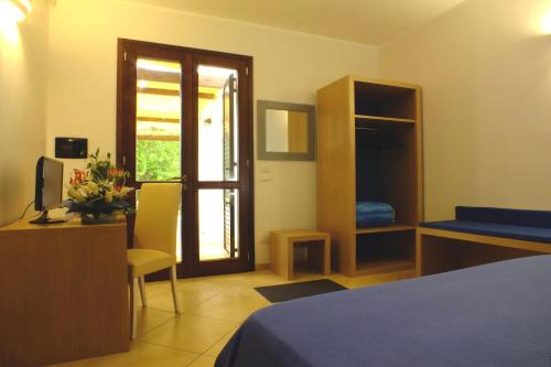 a bedroom with a bed and a door with a window at Agriturismo L'Angela in Borgagne