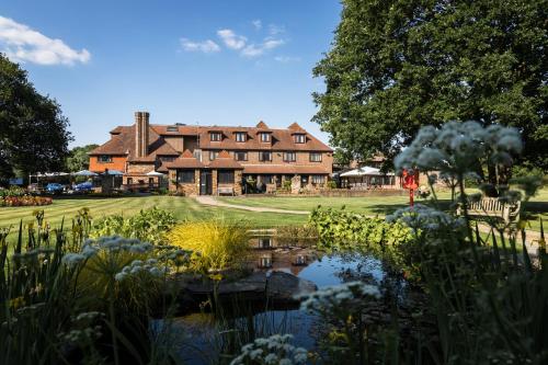 a large house with a pond in front of it at Stirrups Hotel in Bracknell