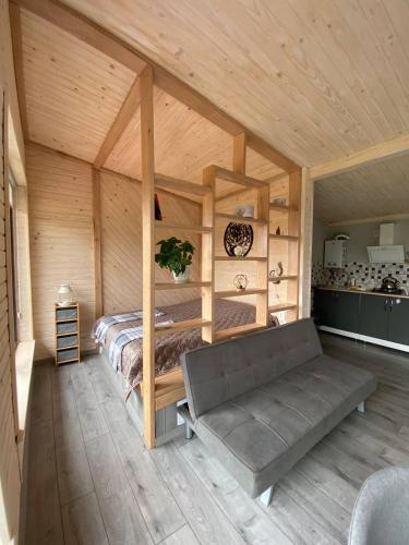 a bedroom with a bed and a couch in a room at Ecottage котедж для двох у горах із чаном-джакузі in Slavske