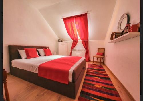 a bedroom with a bed with a red blanket and a window at Nera-etwa Konjic 2 room in Konjic