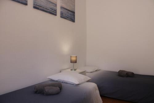 ナザレにあるCasa Pisa Flores - Praia da Nazaréのベッド2台(テーブル上のランプ付)が備わるベッドルーム1室