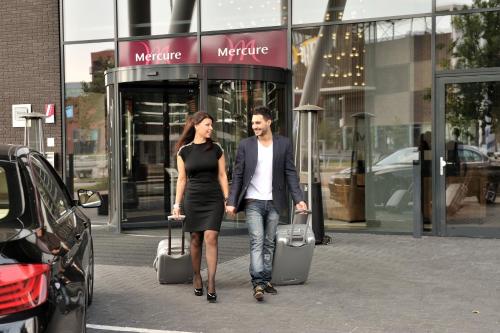 a woman and a man walking down the street at Mercure Hotel Amersfoort Centre in Amersfoort